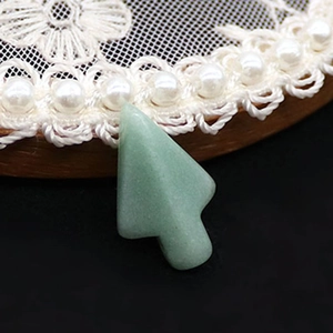 Gros plan d'un pendentif en aventurine verte en forme de sapin de Noël au fini poli