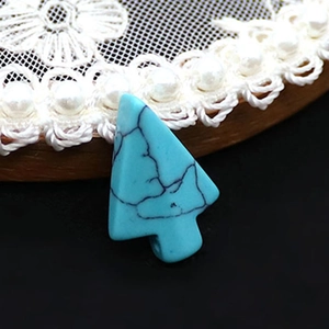 Vue détaillée d'un pendentif en turquoise bleue en forme de flèche avec texture de veines