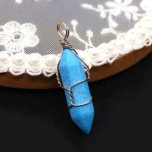 Detailansicht eines blauen Türkis-Anhänger in Sechskantform mit Golddrahtwicklung