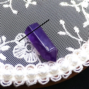Makroaufnahme eines violetten Amethyst-Hexagonal-Kristallprismas mit natürlichen Einschlüssen