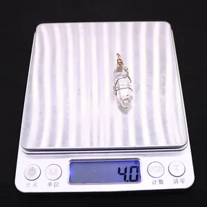 Macro shot showing 4.0g weight of white crystal hexagonal pendant with gold wire wrapping