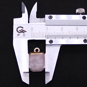 Macro shot of a faceted pink rose quartz square pendant measured with a caliper