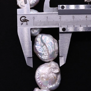 Macro shot of high-quality baroque pearls with iridescent luster measured by a caliper