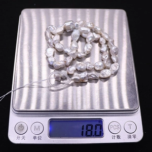 Detail of irregular natural baroque pearls on a digital scale weighing 18.0g