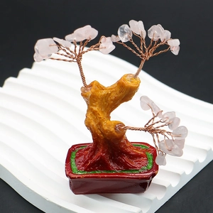 Macro shot of rose quartz crystal tree with copper branches in a red ceramic pot