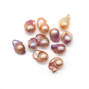 Irregular baroque freshwater pearls in purple and champagne tones on white background