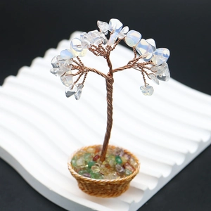Detail of handcrafted wire-wrapped life tree with translucent stones and woven basket base