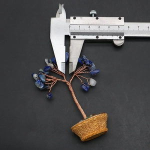 Detail view of mini gemstone tree with blue crystals being measured by a caliper