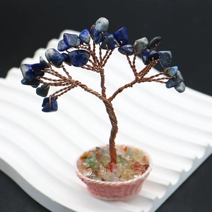 Gros plan d'un arbre à bijoux en lapis-lazuli fait main avec fil de cuivre sur socle rose