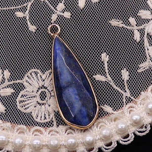 Détail d'un pendentif en lapis-lazuli en forme de goutte avec bordure dorée