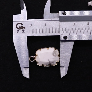 Macro detail van rechthoekige witte marmeren hanger gemeten met een schuifmaat