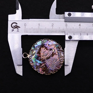 Makroaufnahme eines 28mm runden Abalone-Anhänger mit goldenem, gezacktem Fassungsrand