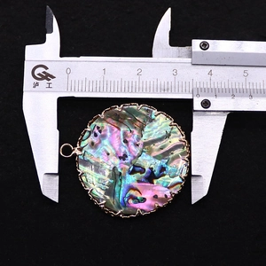 Makroaufnahme eines 34mm runden Abalone-Anhängers mit goldenem Wellenrand und Messung