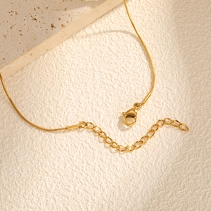 Détail du collier chaîne serpent dorée avec fermoir mousqueton et extension réglable