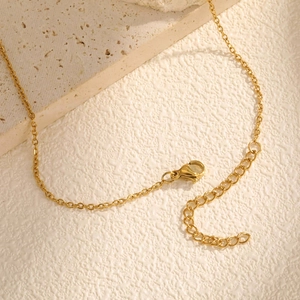 Goldene Edelstahl O-Kette mit Karabinerverschluss auf elegantem weißem Stein Hintergrund