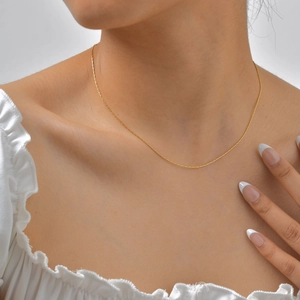 Primer plano de una fina cadena de acero inoxidable bañada en oro de 18K