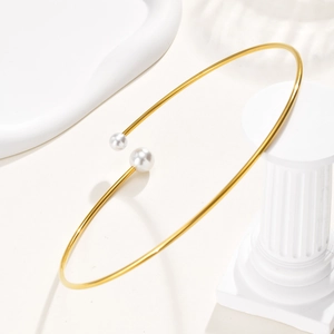 Dettaglio macro del girocollo placcato oro minimalista con due eleganti perle bianche
