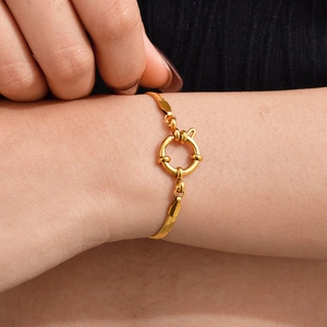 Κοντινό πλάνο χρυσού βραχιολιού αλυσίδα φίδι με μεγάλο κούμπωμα ναυτικό στον καρπό
