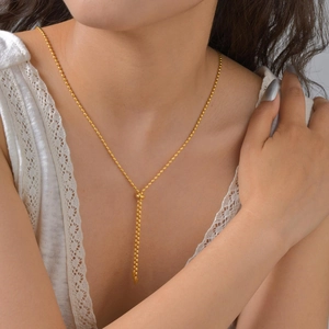 Elegante collar de acero inoxidable dorado con cuentas de arroz y colgante de borla larga