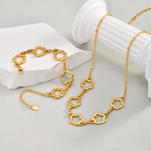 Set collana e bracciale dorati con fiori traforati su base in pietra minimalista