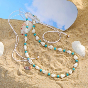 Verstellbare goldene Meeres-Halskette mit Türkisperlen und echten Muscheln am Strand