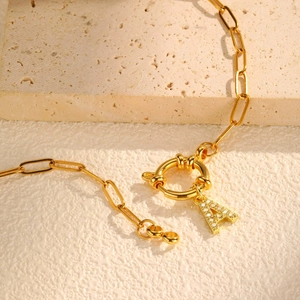 Close-up of 18K gold-plated paperclip chain with a crystal-encrusted letter A pendant
