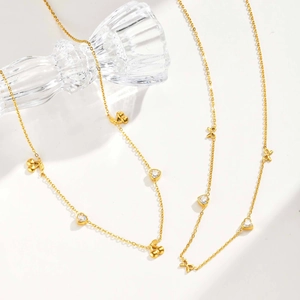 Golden necklace featuring heart zircons, cherry pendants and elegant bow details