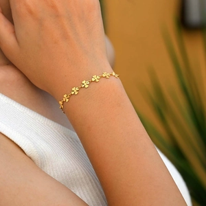 Elegante bracciale a maglie con quadrifoglio dorato indossato per un look alla moda