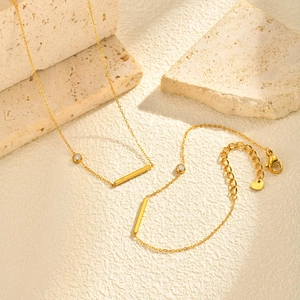 Détails de parure collier et bracelet dorés avec barres rectangulaires et zircon