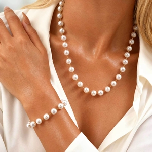 Elegant pearl jewelry set with necklace and bracelet featuring gold metal accents