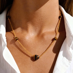 Détail du collier vintage en acier plaqué or 18 carats avec cœur et pierres œil de tigre