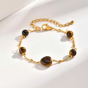 Détail du bracelet plaqué or 18 carats avec pierre en forme de cœur et perles œil de tigre