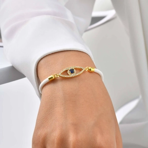 Elegant evil eye bracelet with blue stone and gold plating on white woven cord