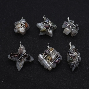 Macro detail of six handmade wire-wrapped pendants with natural pearls on black background