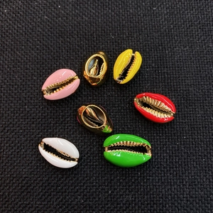 Macro shot of colorful enamel conch shell beads with gold plated edges for DIY jewelry making