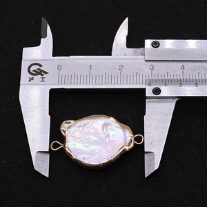 Macro detail of natural freshwater baroque pearl connector with gold edge measuring 28mm