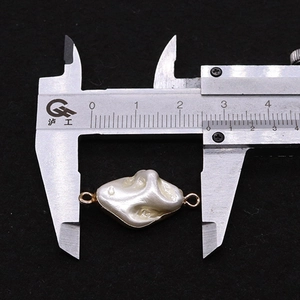 Macro shot showing irregular baroque pearl connector with 24mm measurement scale