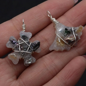 Detailed macro view of handmade wire-wrapped crystal and shell pendants on black background