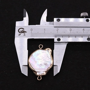 Macro detail of a 18.5mm baroque pearl pendant with gold rim and dual connector loops