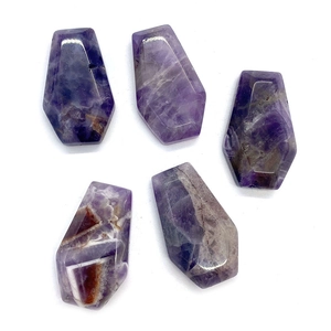 Macro view of five faceted amethyst coffin stones with natural purple mineral textures
