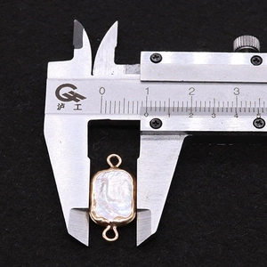 Caliper measurement of a rectangular baroque pearl connector with gold frames