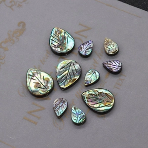 Dettaglio macro di perline a foglia in conchiglia di abalone con trame iridescenti verde-blu