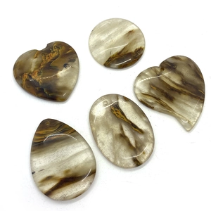 Vue détaillée de cinq pendentifs en agate naturelle en formes de cœur, rond et ovale