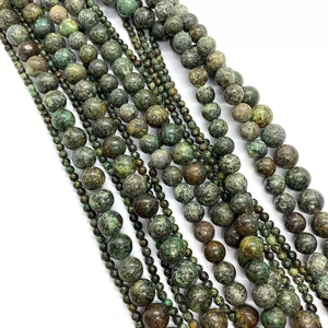 Macro detail of African Turquoise round beads with natural green and brown textures