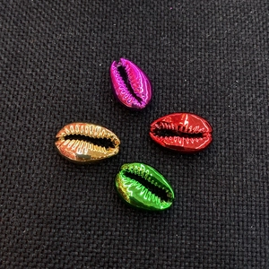 Metallic plated natural shell beads in vibrant red, purple, and gold on dark fabric