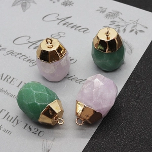 Macro detail of faceted green and purple stone pendants with gold metal caps