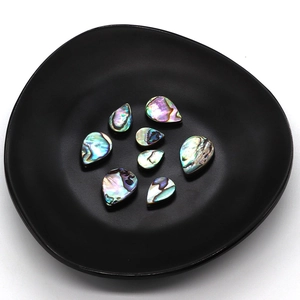 Lot de 8 perles en nacre d'abalone en forme de goutte sur un plateau noir élégant