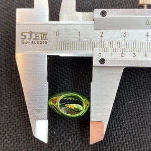 Macro shot of an 18mm green electroplated seashell bead measured with a caliper