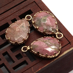 Vue macro de pendentifs en pierre naturelle en forme de goutte avec griffes dorées