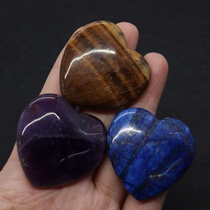 Gros plan de pierres en forme de cœur en œil de tigre, améthyste et lapis-lazuli